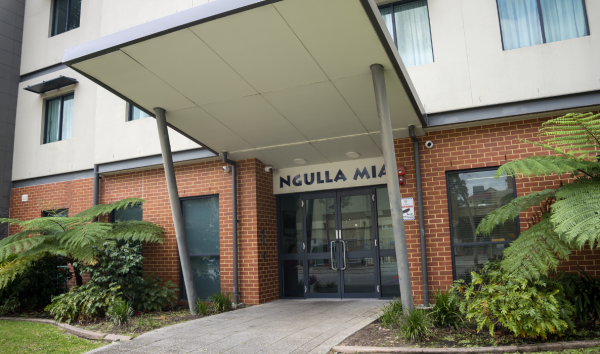 Entrance to Ngulla Mia Supported Accommodation, a building with brick on the bottom and cream coloured walls above