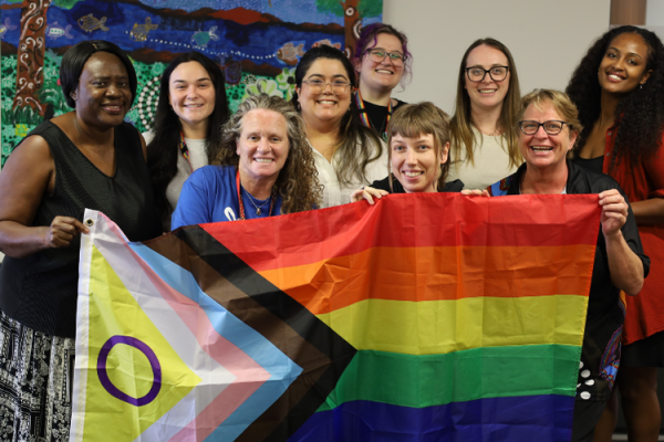 group of people holding an intersex inclusive progress lqbtqia+ pride flag