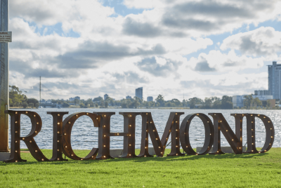 A Richmond light display turned off during the day on the grass in front of the river