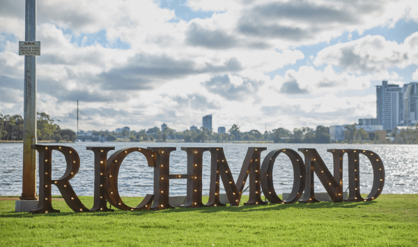A Richmond light display turned off during the day on the grass in front of the river