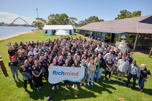 A large group of people standing together for U&I Day and holding up a Richmind WA sign