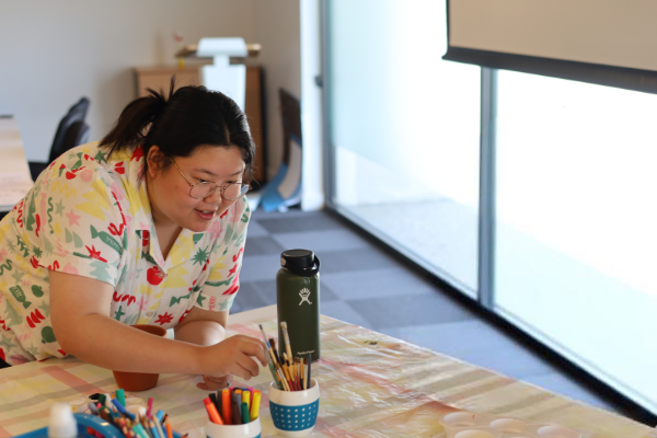 A woman at a table reading for a paint brush