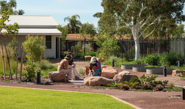The outdoor area of the Karratha Step Up/Step Down service building with a few women sitting on some rocks
