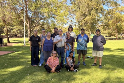 A group of people posing together on the grass in front of trees on the MDW tour