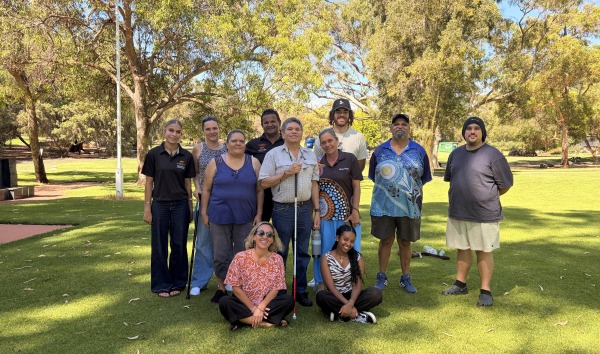 A group of people posing together on the grass in front of trees on the MDW tour