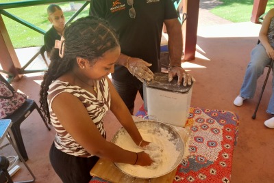 A girl kneading dough in a bowl