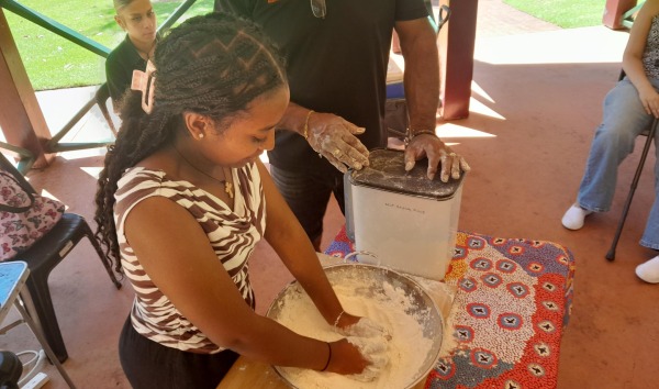 A girl kneading dough in a bowl