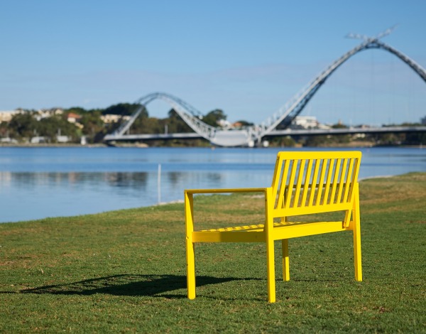 Yellow Bench on grass next to river