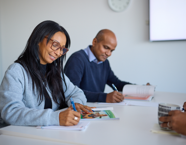 Two people filling in worksheets at a trauma de-escalation workshop