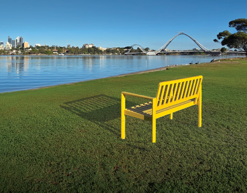 Yellow Bench on grass in front of river